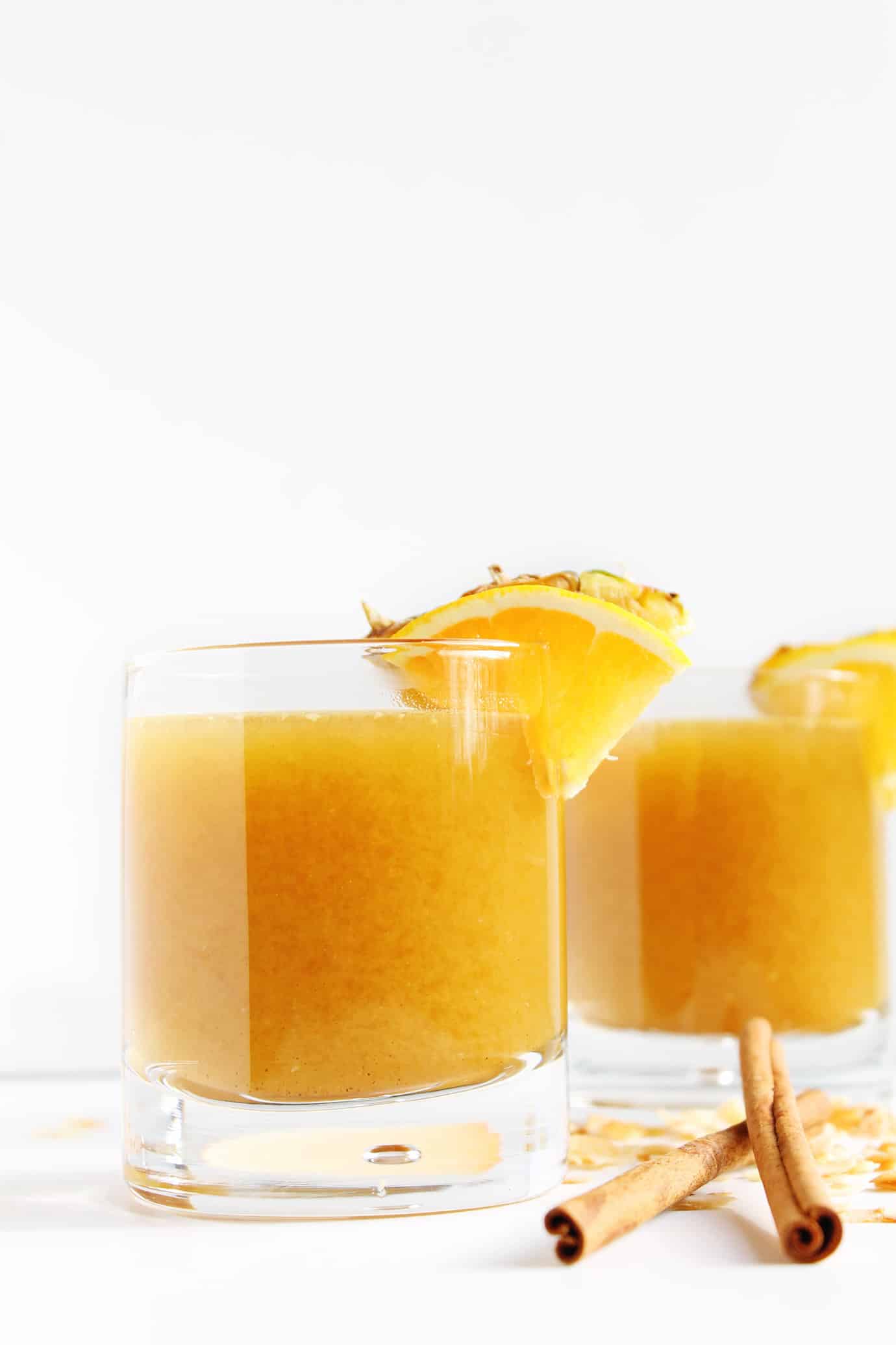 Pineapple cider rum cocktail recipe! Pineapple juice is mulled with cinnamon, orange, coconut, and other spices, then chilled and mixed with dark spiced rum. Such an awesome Fall or Winter cocktail!