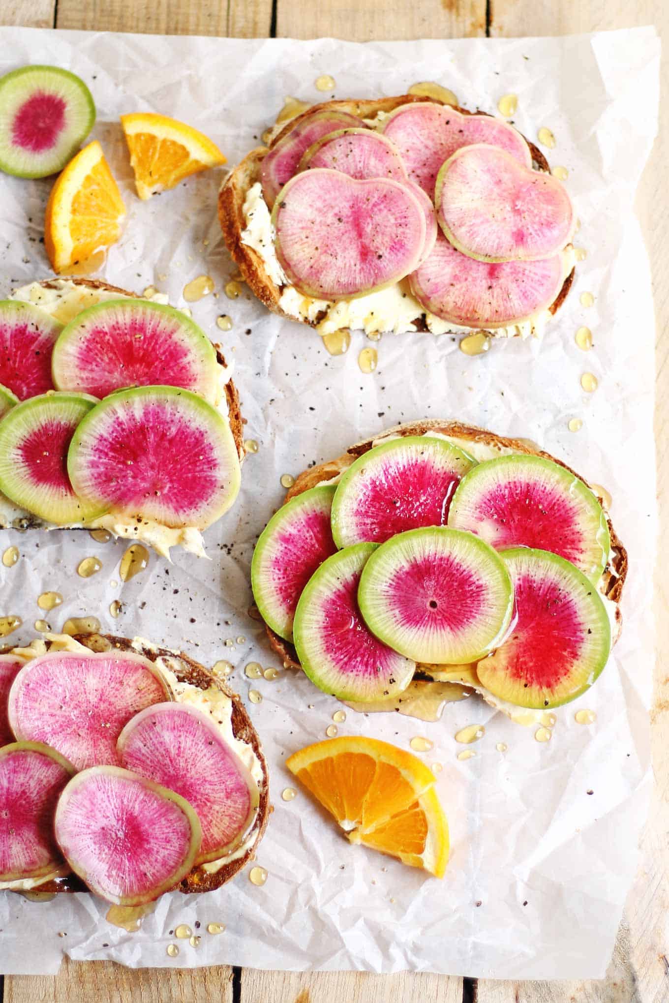 The perfect vegetarian farmers market lunch in only 10 minutes! Bright and springy watermelon radish toast with orange mascarpone and honey recipe. Peppery radishes, mascarpone whipped with orange zest, and sweet honey. // Rhubarbarians