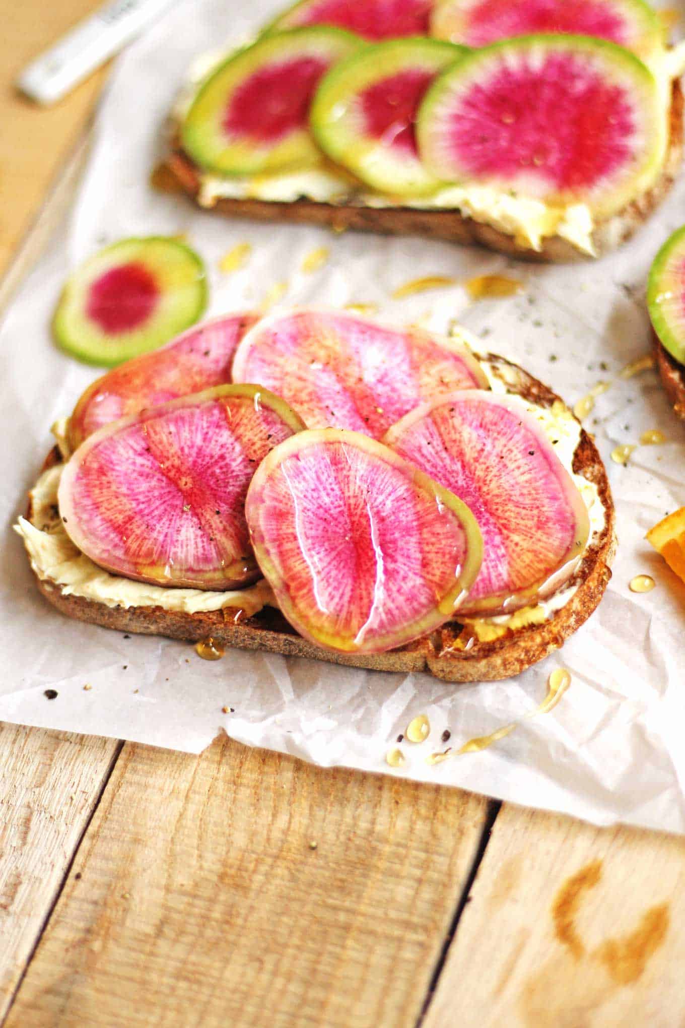The perfect vegetarian farmers market lunch in only 10 minutes! Bright and springy watermelon radish toast with orange mascarpone and honey recipe. Peppery radishes, mascarpone whipped with orange zest, and sweet honey. // Rhubarbarians