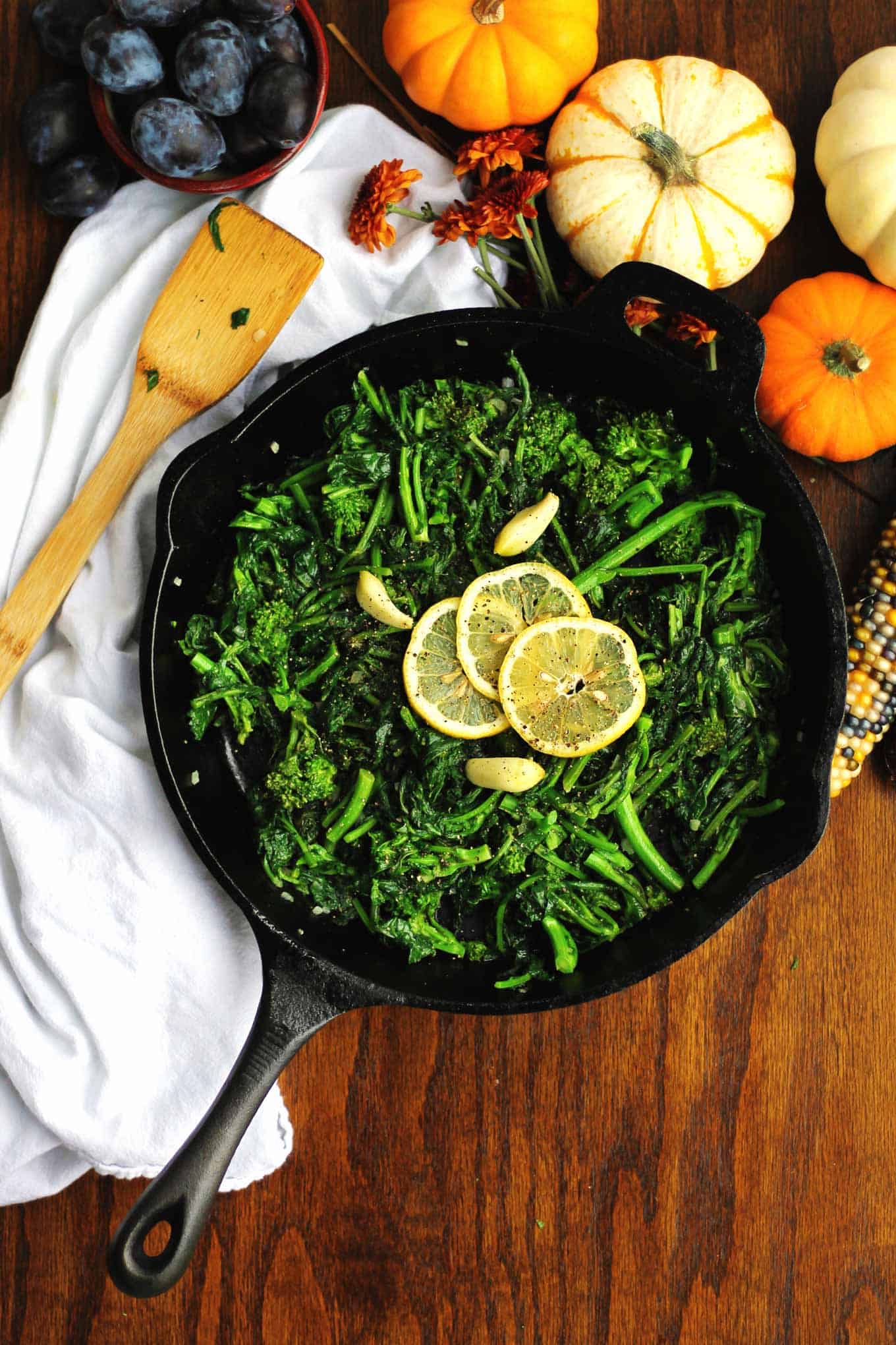 sauteed broccoli rabe in a black skillet with lemon slices