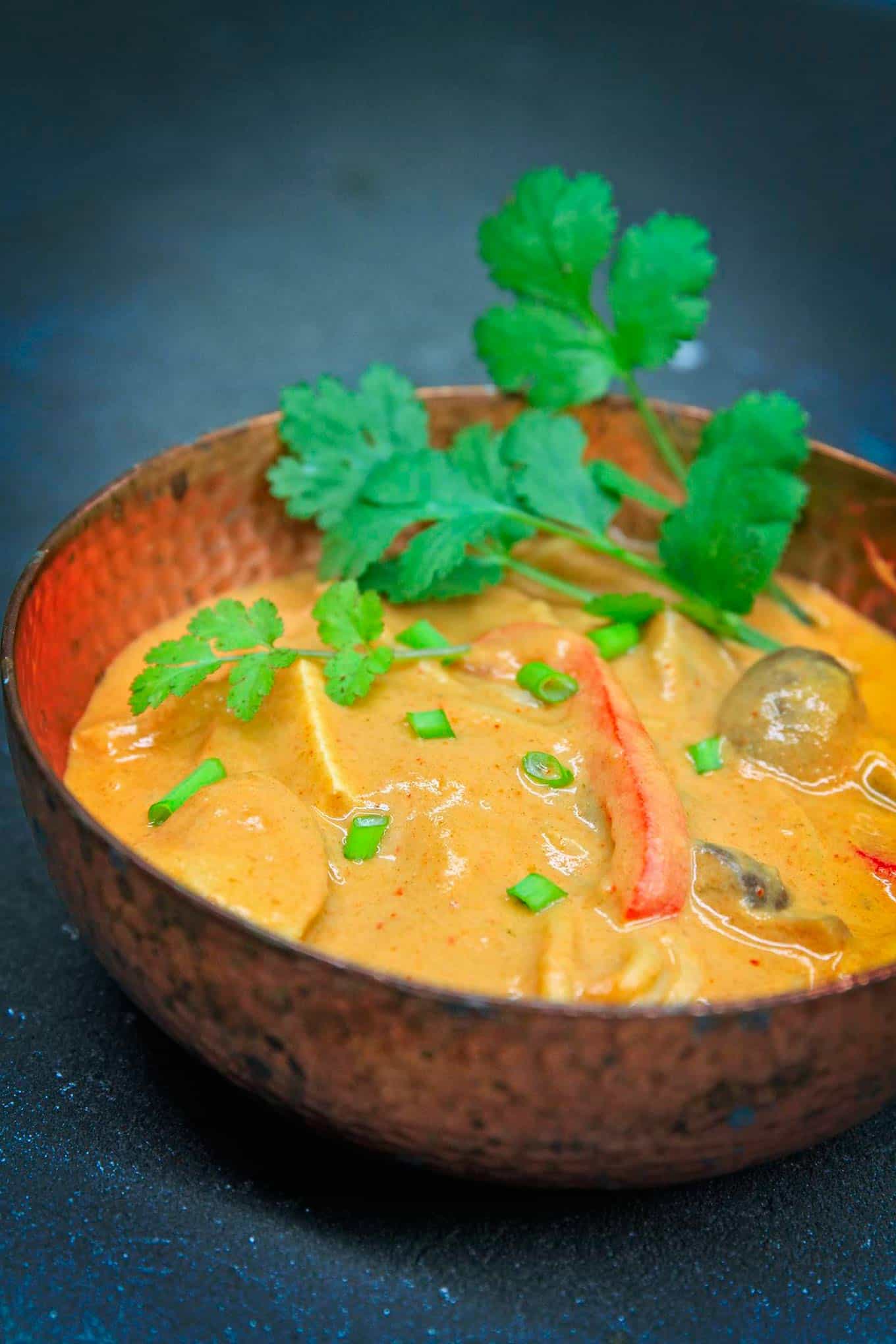 vegan thai peanut soup in a red bowl