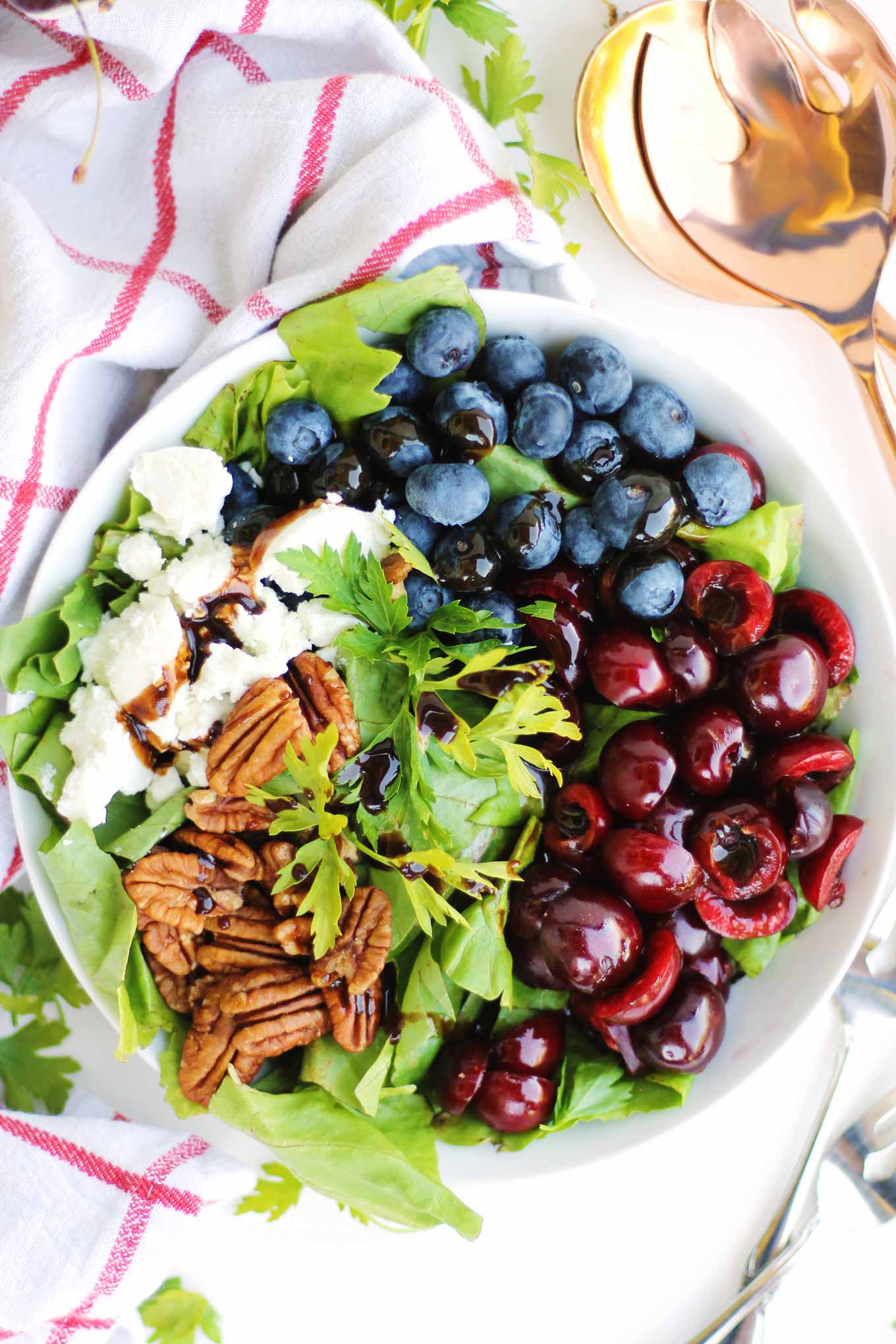 Cherry blueberry salad with pecans and goat cheese with a red and white towel