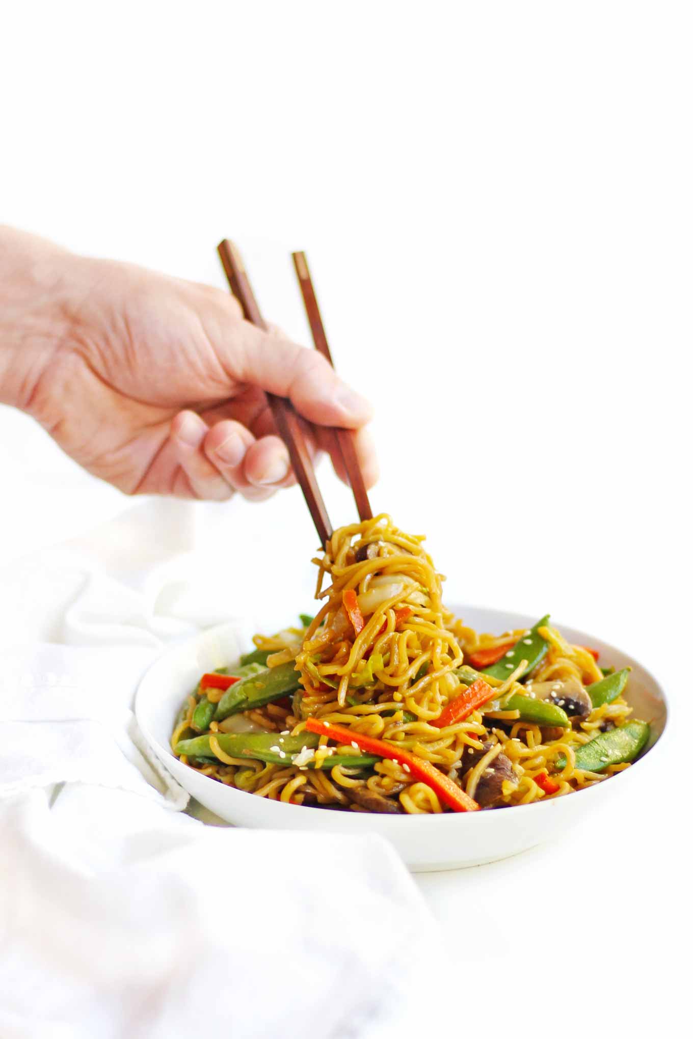 stir fry noodles being eaten with chopsticks