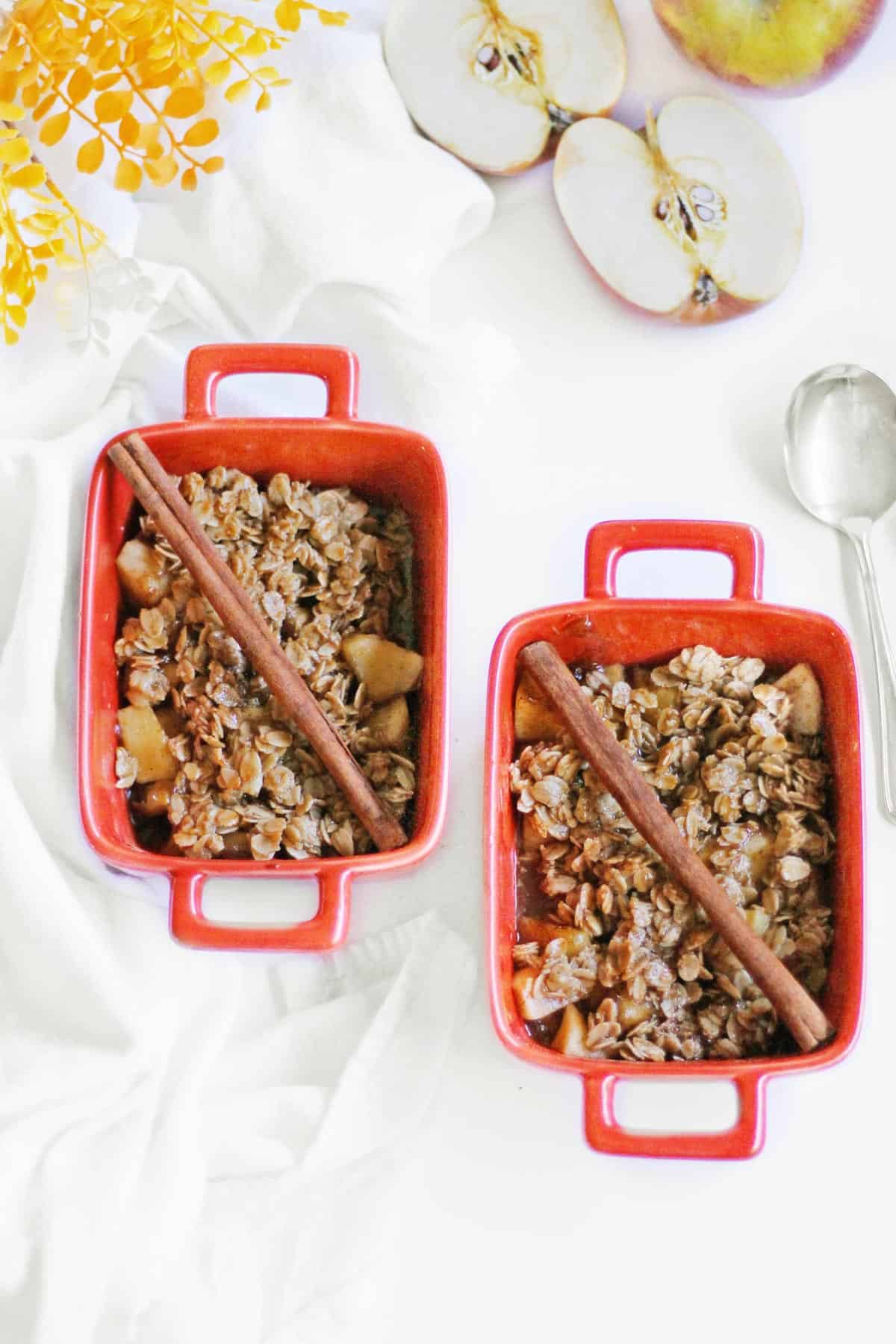 two single serve apple crisps in red ramekins