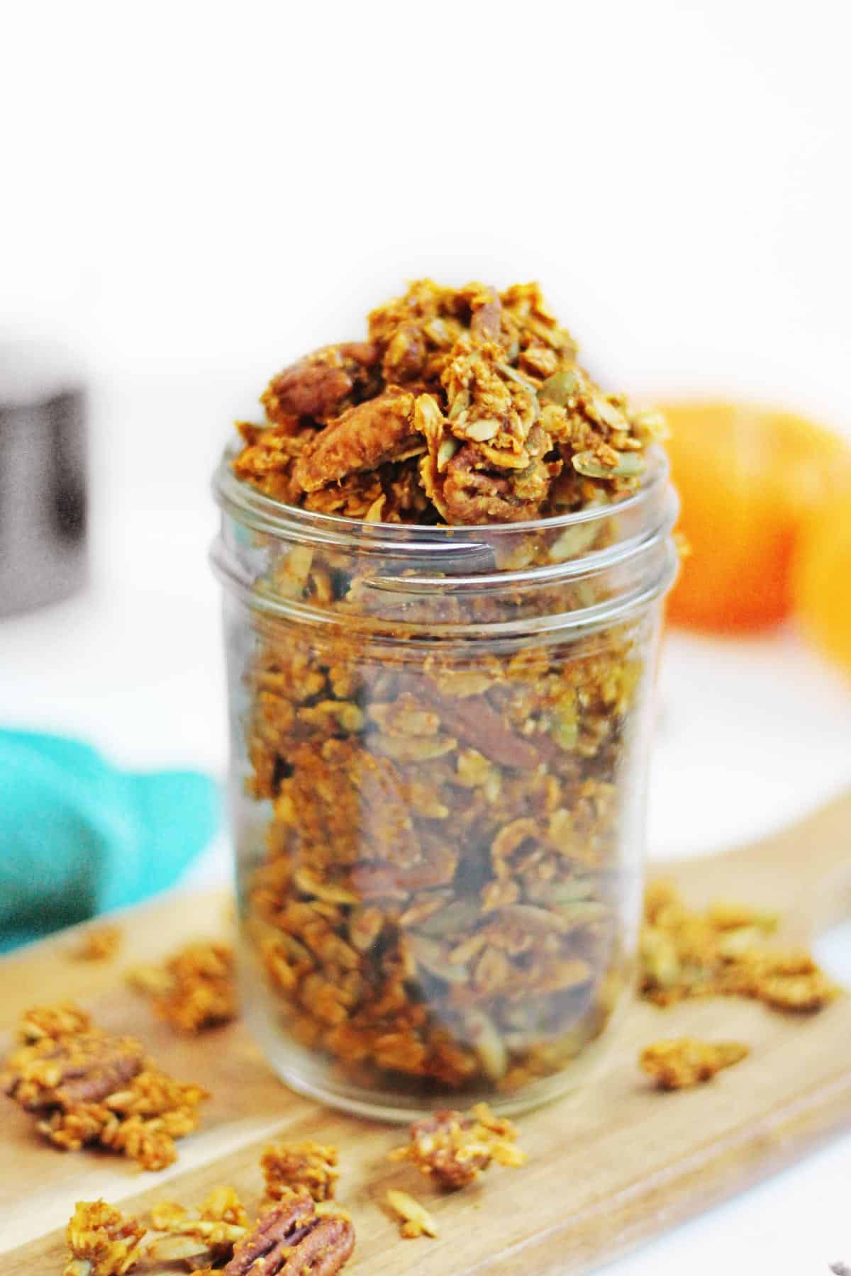 A photo of pumpkin granola in a small glass mason jar.
