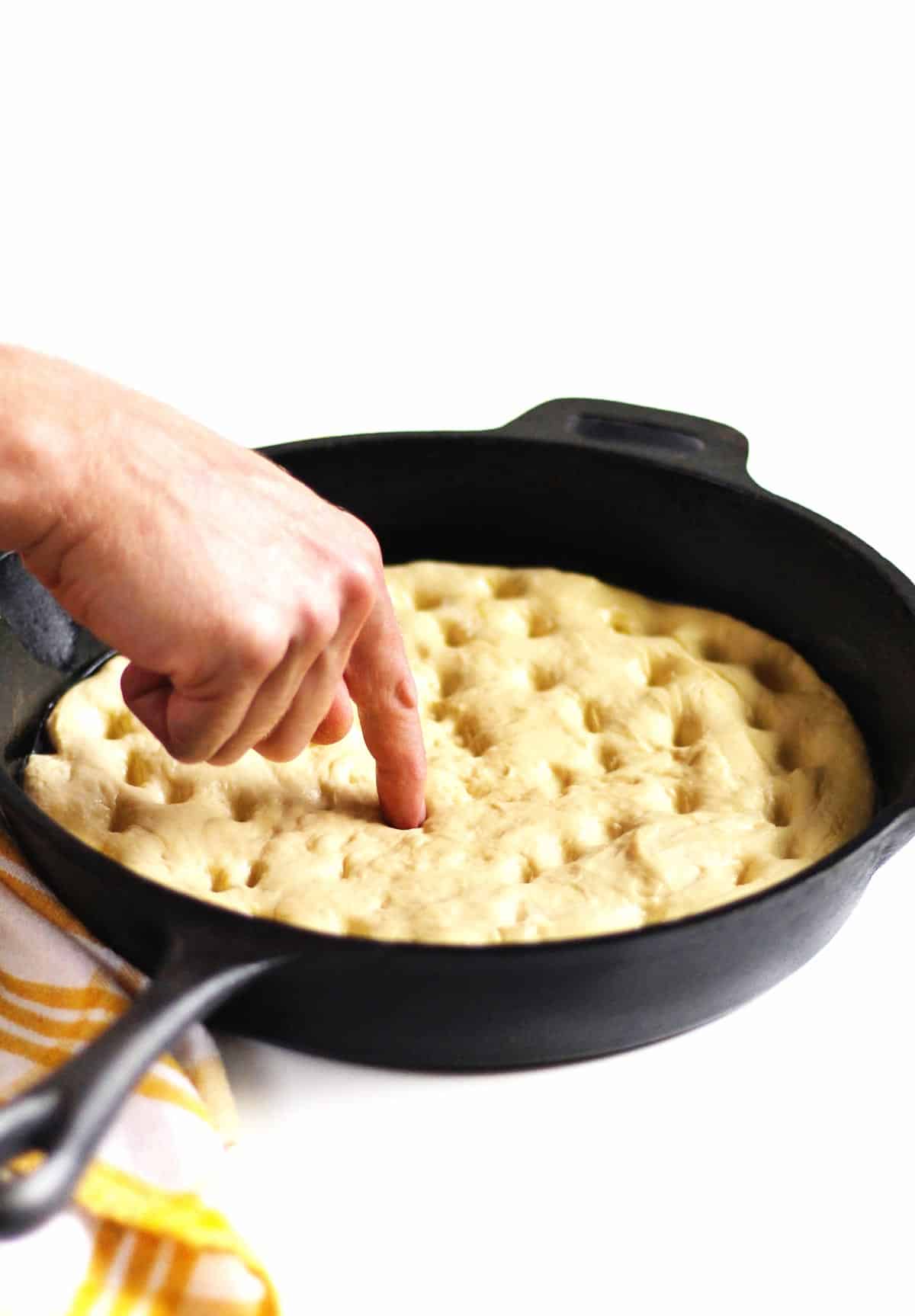 poking focaccia bread dimples