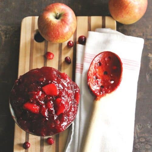 Cranberry sauce with wooden spoon and apples