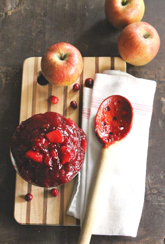 Cranberry sauce with wooden spoon and apples