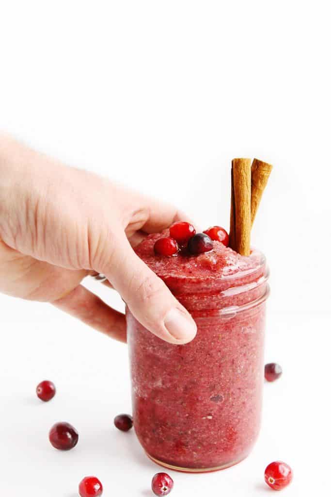 hand picking up a cranberry smoothie