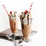 Red wine milkshake with whipped cream chocolate syrup and straws