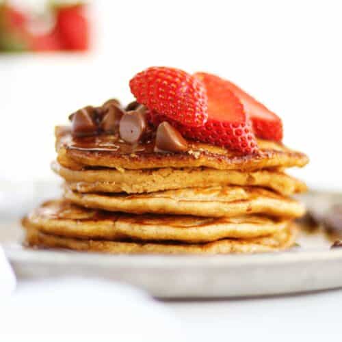 Stack of oat flour pancakes with strawberries and chocolate chips