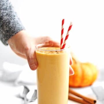Pumpkin smoothie with hand picking it up