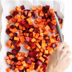 Sweet potatoes and beets on a sheet pan with parchment paper