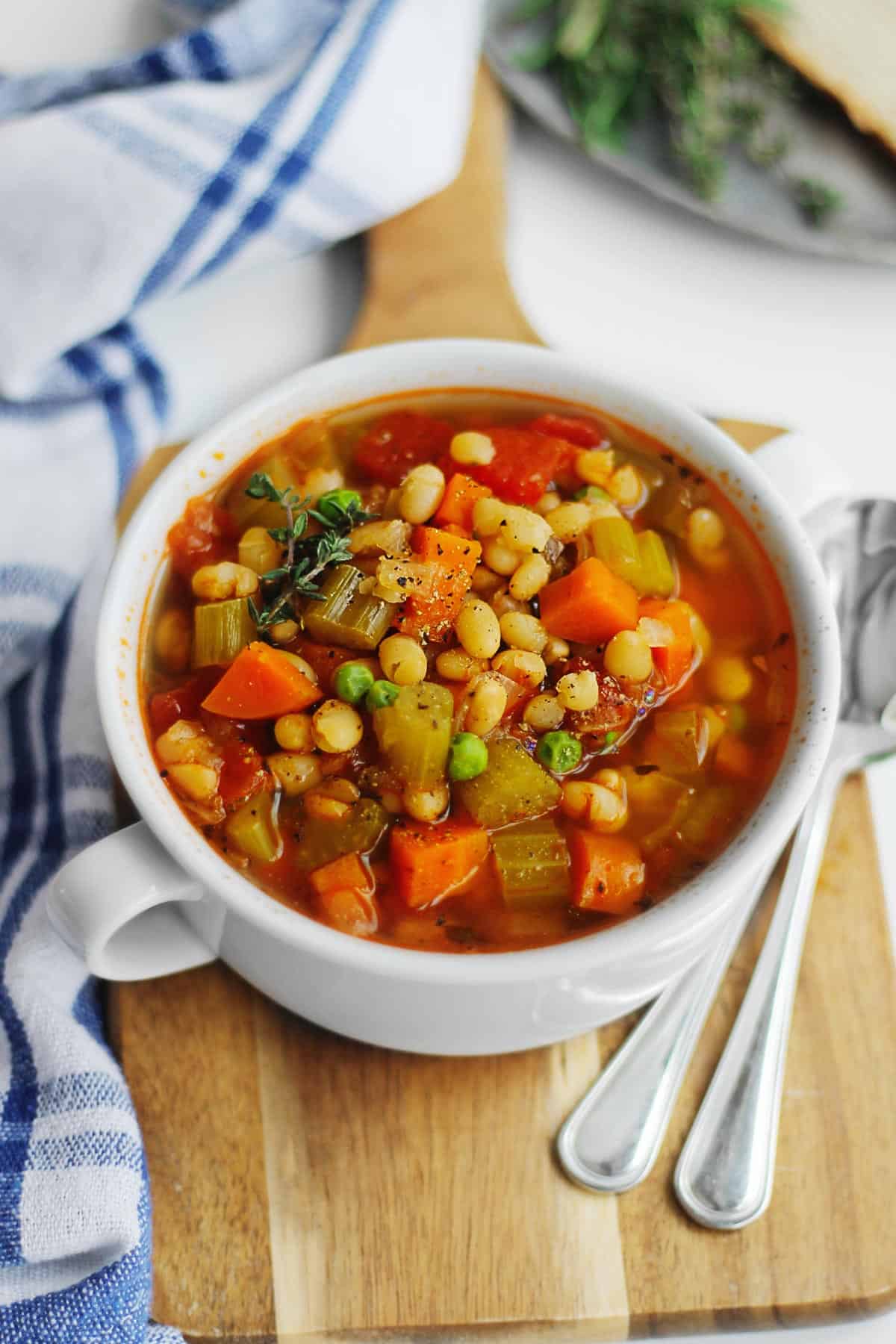 A picture of white bean vegetable soup in a white soup bowl