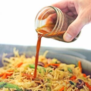 Vegan stir fry sauce pouring over noodles