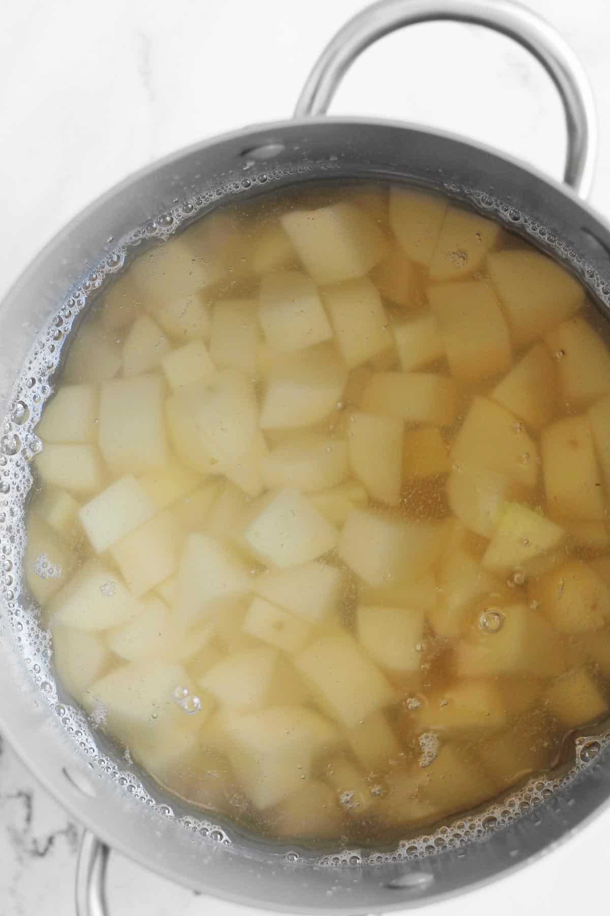 Water over cubed potatoes in a large pot