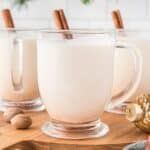 Eggnog in a glass mug with a cinnamon stick