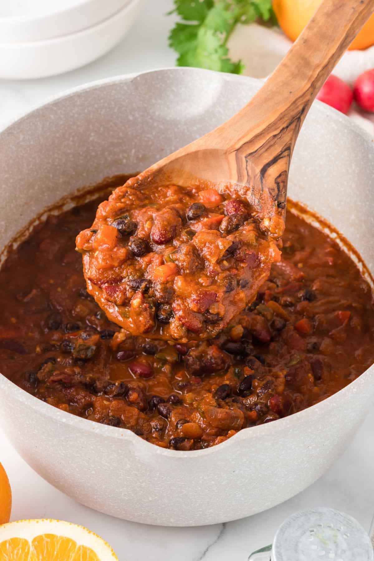 Scoop of bean chili on a wooden spoon