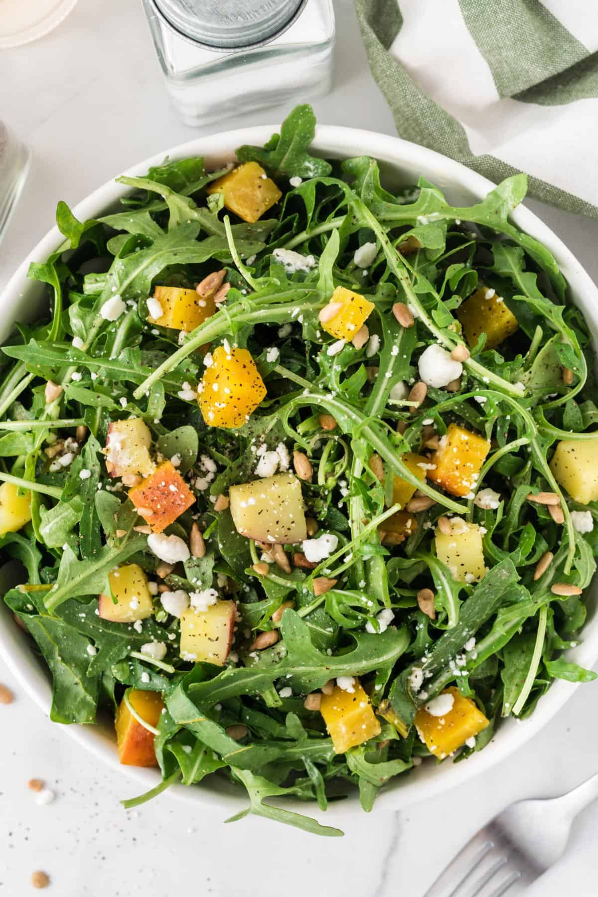 A close up picture of a salad with arugula and golden beets