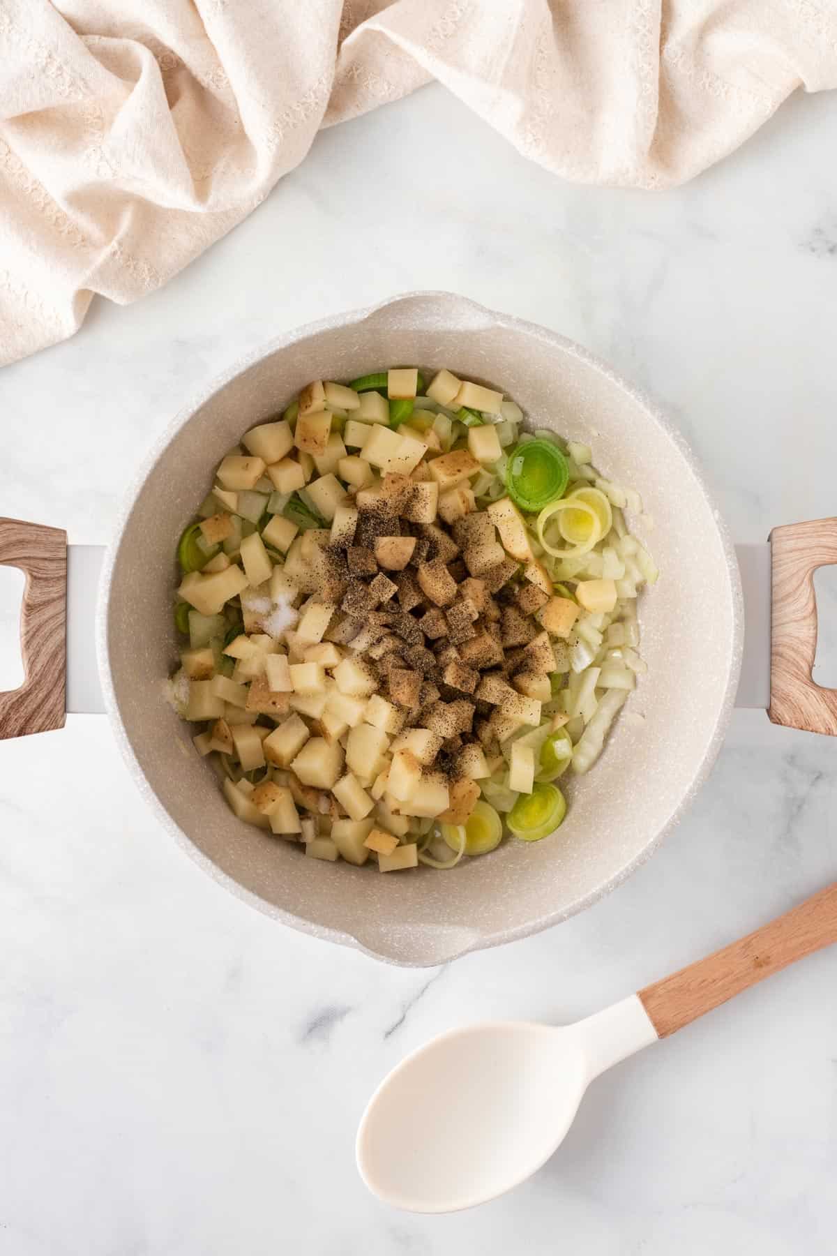 A picture of cooking potatoes and leeks in a pan.