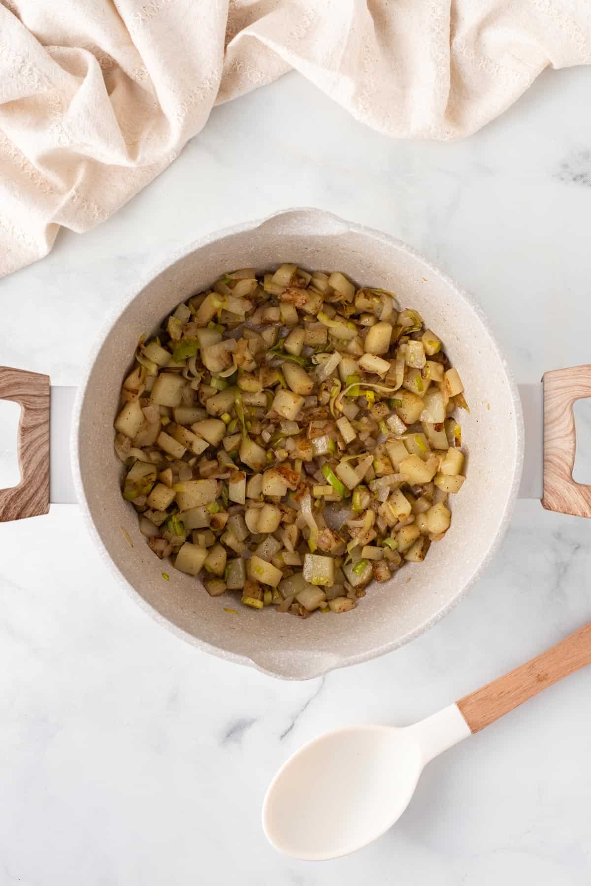 A picture of cooking potatoes and leeks in a pan.