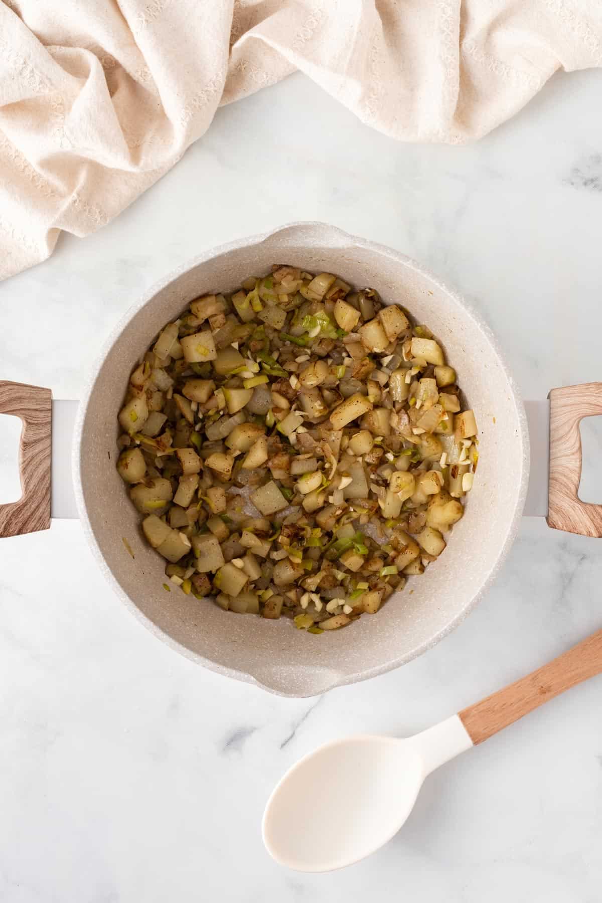 A picture of cooking potatoes and garlic in a soup pot.