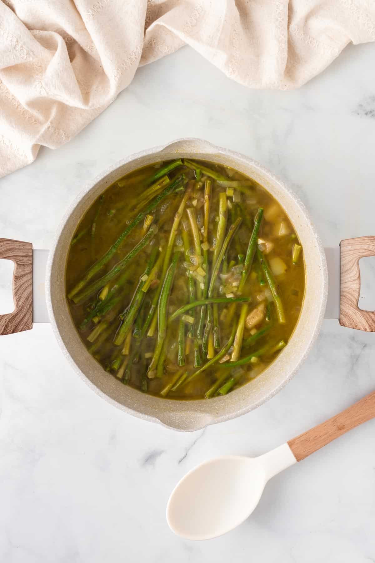 A picture of asparagus soup cooking in a pot.