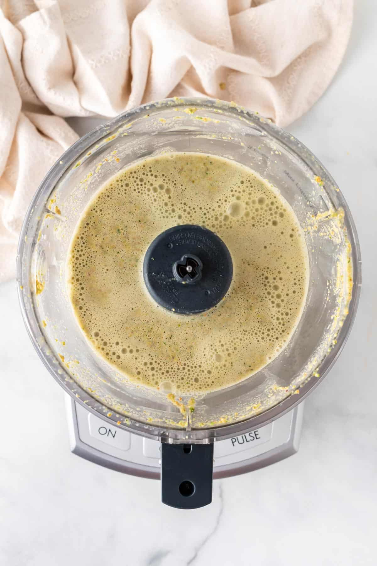 A picture of pistachio cream blended in a food processor.
