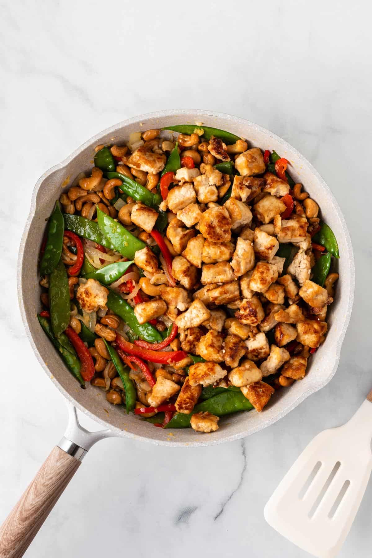 A picture of honey cashew tofu stir fry in a white skillet.