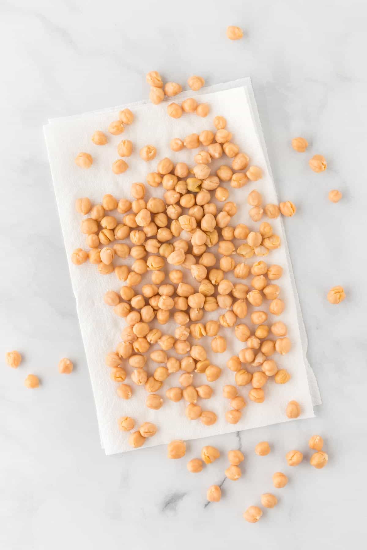 A photo of chickpeas scattered on a paper towel.