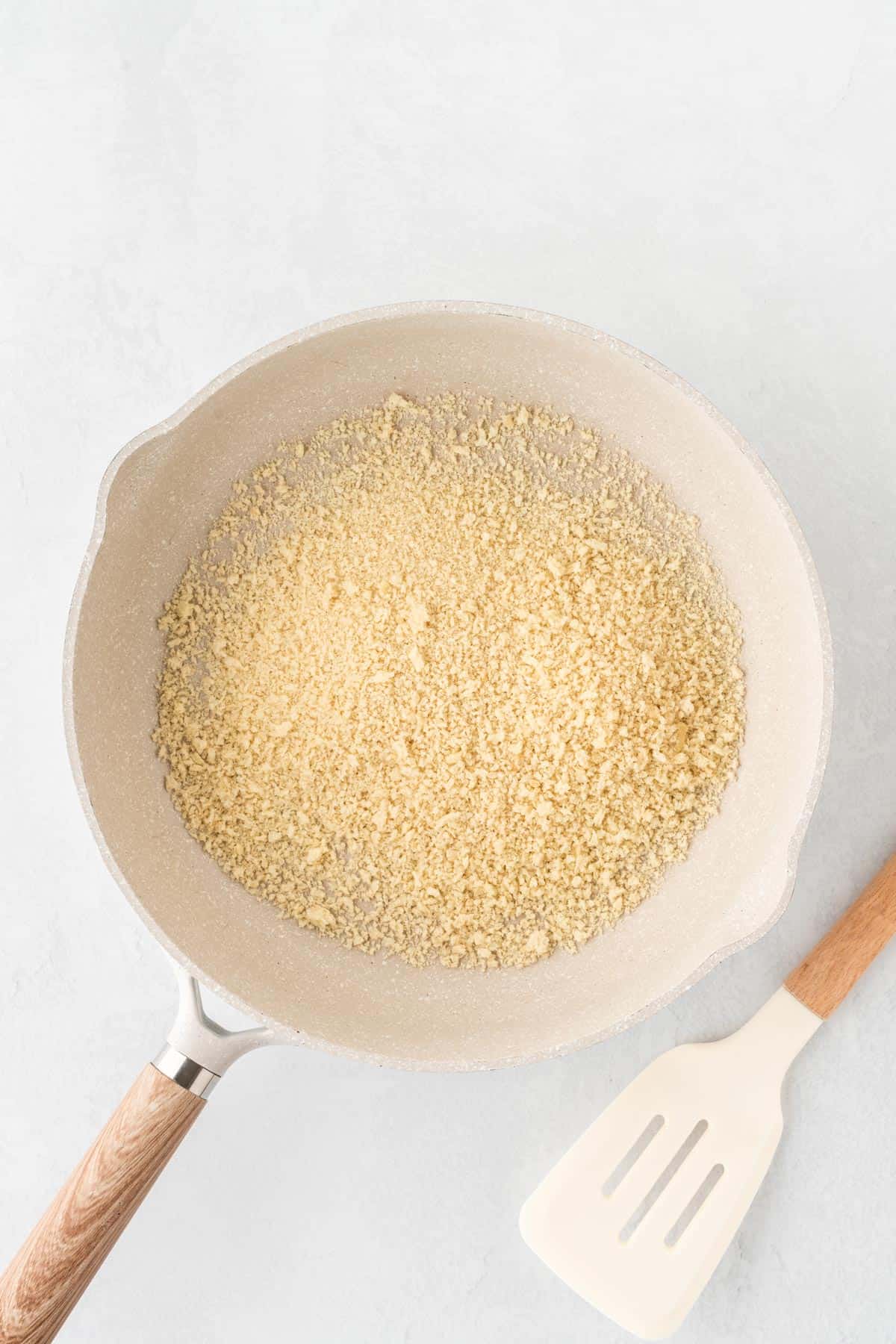 A photo of breadcrumbs in a white skillet.