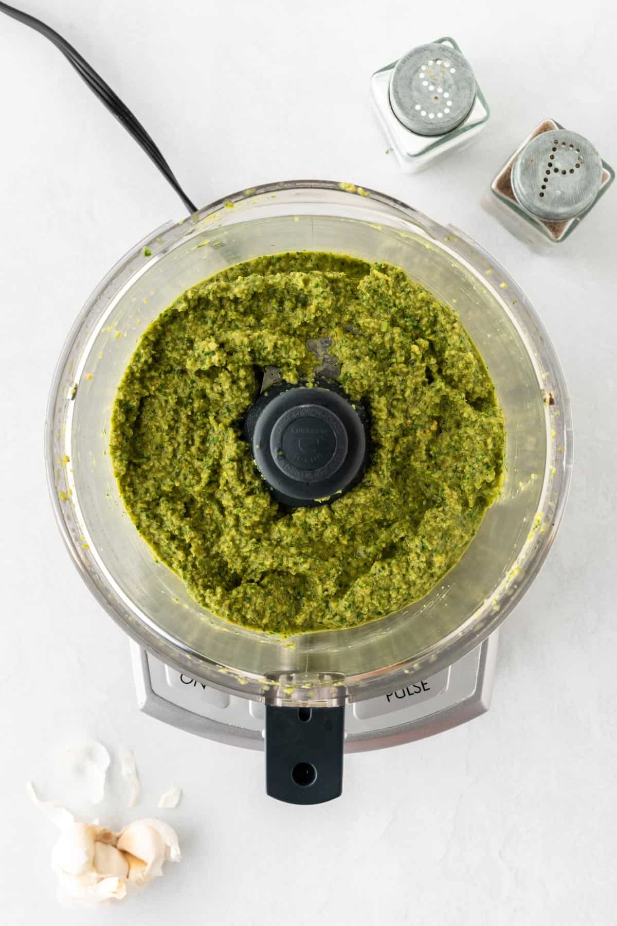 A photo of green olive sauce blended in a food processor.