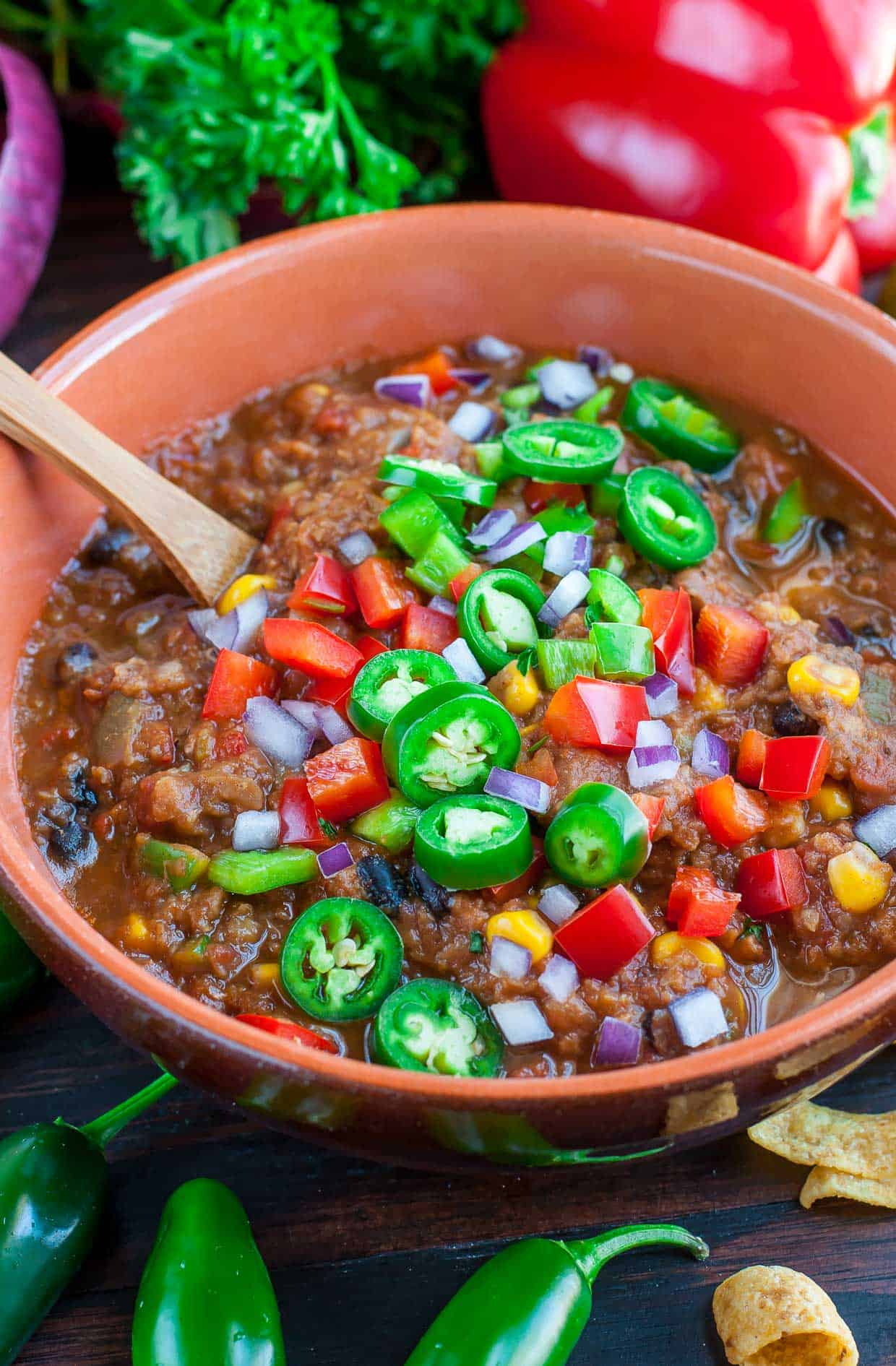 A close up photo of lentil chili in a brown bowl.