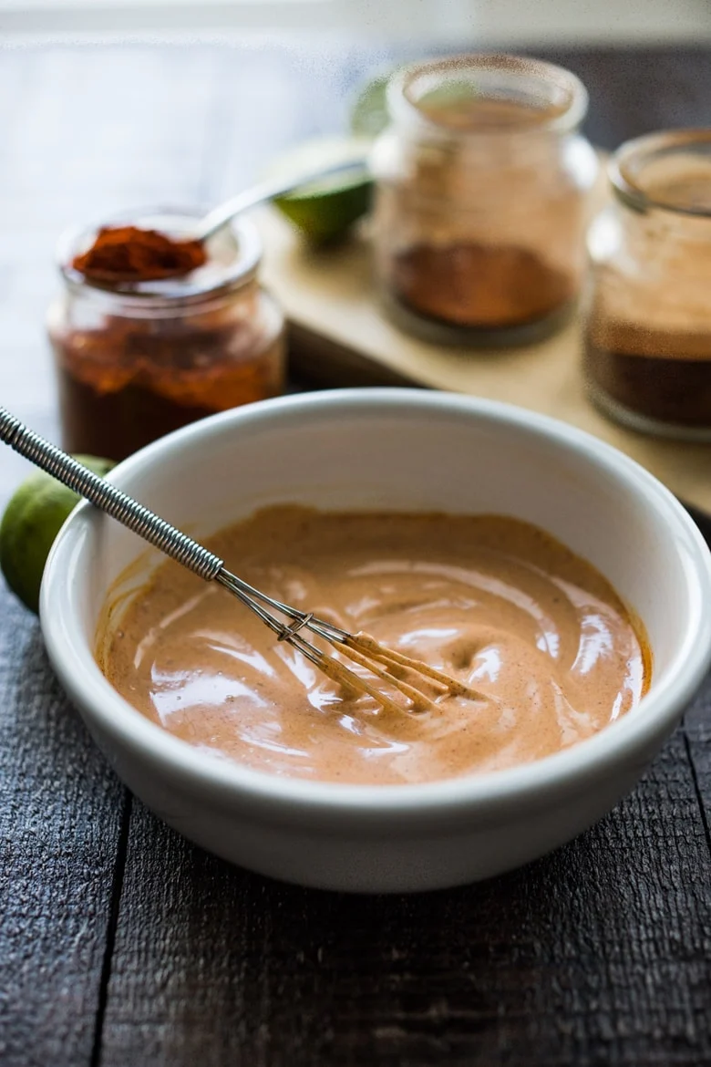 A photo of chipotle mayo in a small bowl with a small whisk.