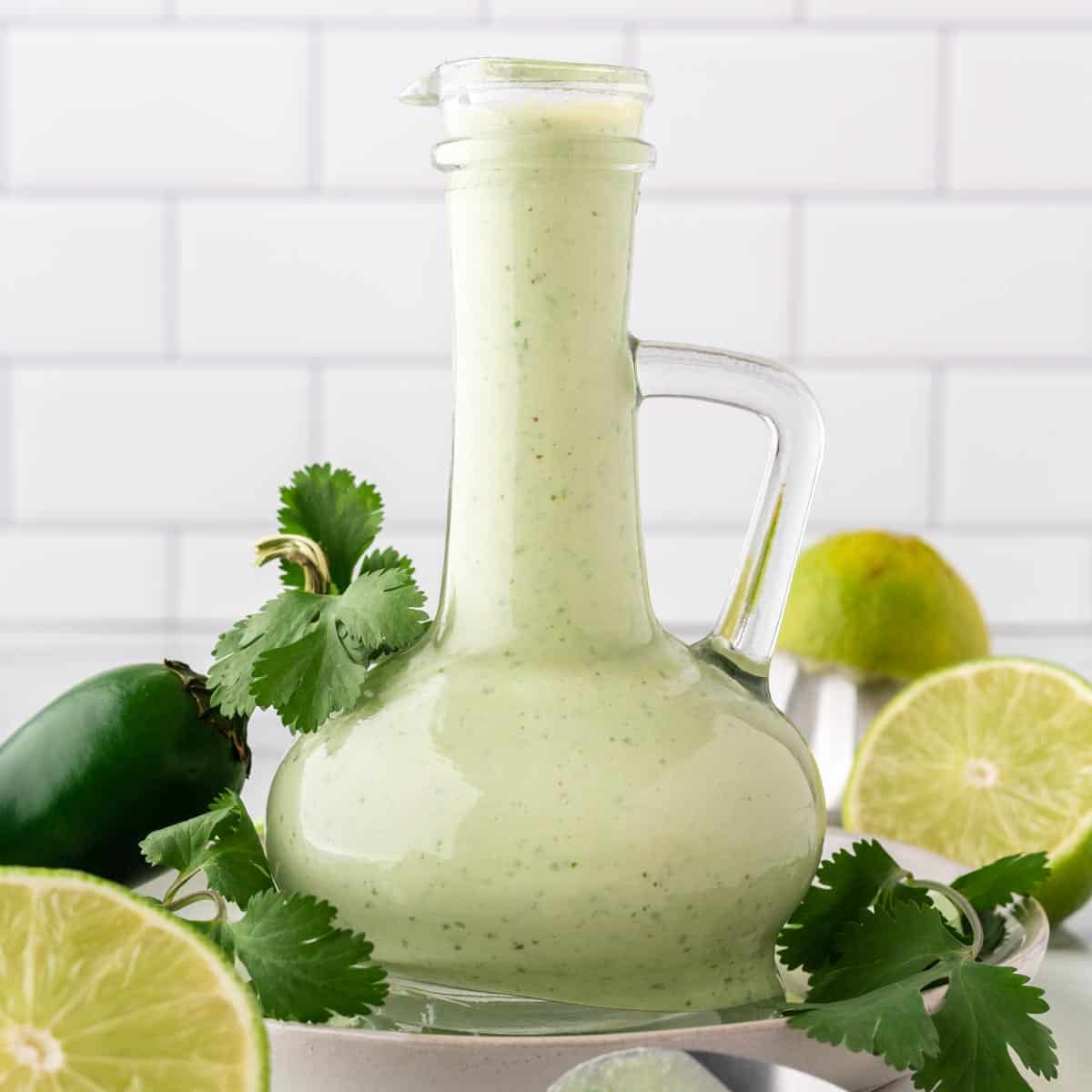 A photo of a carafe of creamy cilantro sauce.