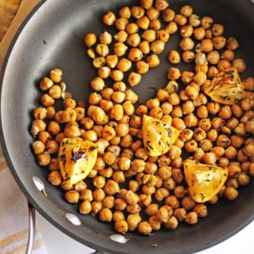 A photo of sauteed chickpeas with lemon in a pan.