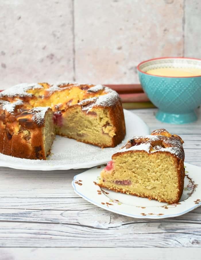 A photo of a slice of rhubarb custard cake on a white plate.