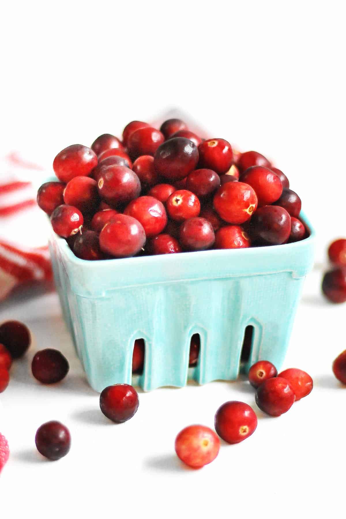 A photo of fresh cranberries in a farmers market basket.