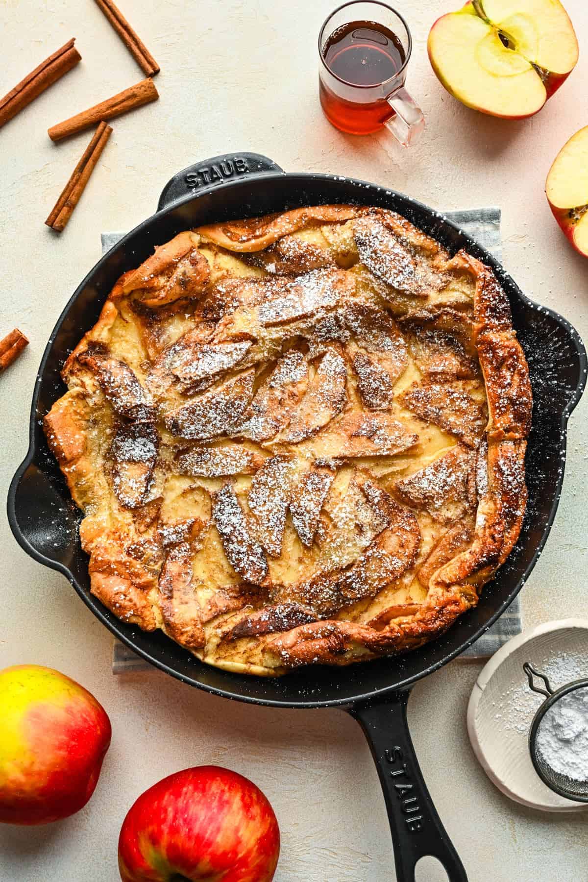 A photo of a German apple pancake in a cast iron skillet.