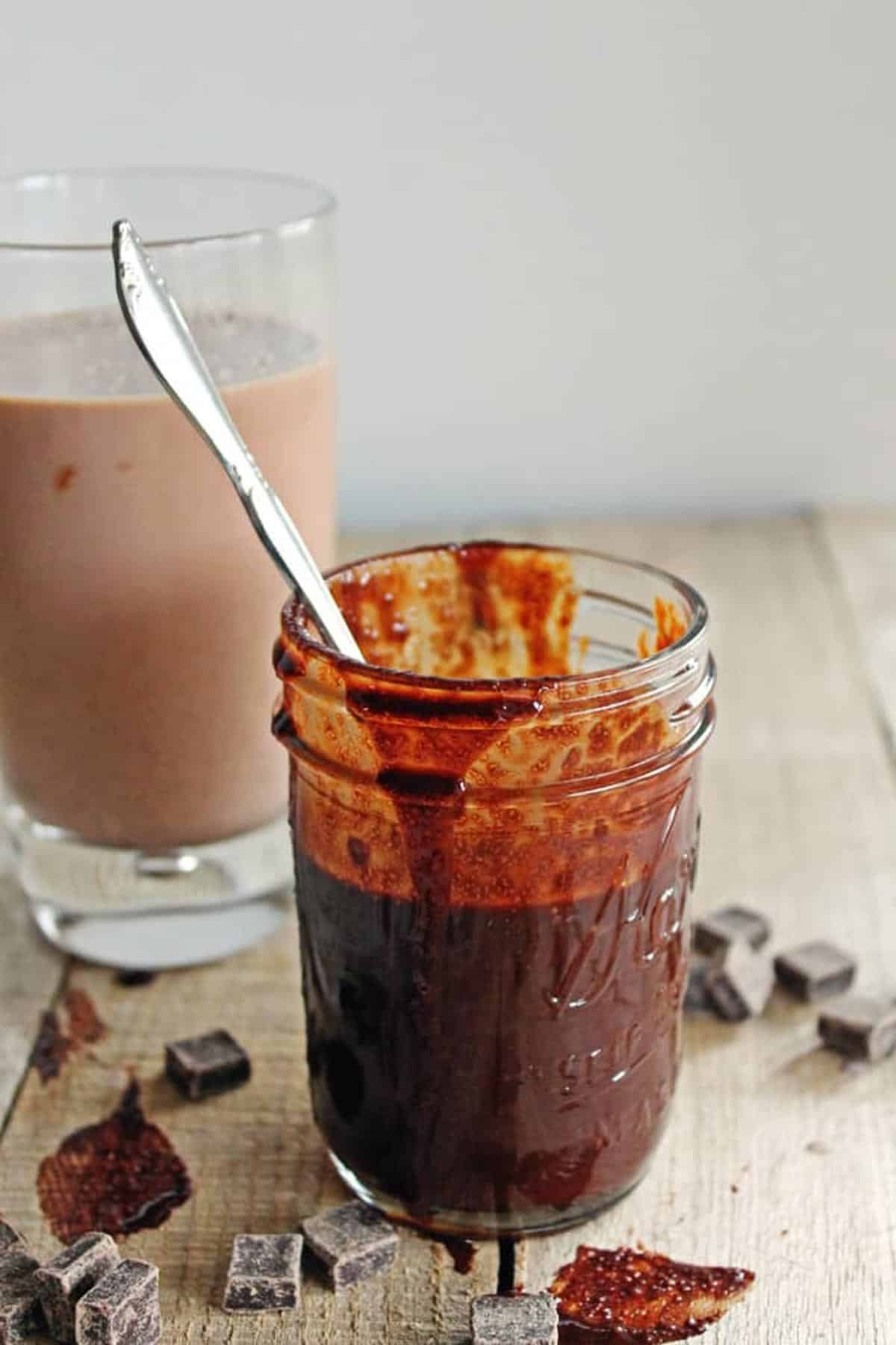 A photo of chocolate peanut butter sauce in a glass jar spilling over the sides.